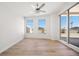 Bright bedroom with light wood floors, ceiling fan, sliding glass door to the patio, and large windows at 11 San Marco St # 307, Clearwater Beach, FL 33767