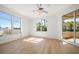 Spacious bedroom with light wood floors, a ceiling fan and plenty of natural light from the large windows at 11 San Marco St # 307, Clearwater Beach, FL 33767