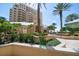 Exterior view showcasing the building's facade, landscaping, and tropical surroundings at 11 San Marco St # 307, Clearwater Beach, FL 33767