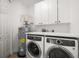 Well-organized laundry room with white cabinets, modern washer, and dryer at 11 San Marco St # 307, Clearwater Beach, FL 33767