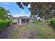 Backyard view featuring the screened lanai and lush landscaping at 1171 Corinth Greens Dr, Sun City Center, FL 33573