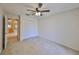 Bright bedroom with neutral carpet and ceiling fan, next to the kitchen and a closet at 1171 Corinth Greens Dr, Sun City Center, FL 33573