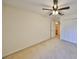 Bedroom with neutral colored carpet, ceiling fan, and a closet next to the bathroom at 1171 Corinth Greens Dr, Sun City Center, FL 33573