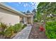 Inviting front entrance featuring a tiled walkway, colorful flowers, and manicured landscaping at 1171 Corinth Greens Dr, Sun City Center, FL 33573