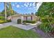 Home exterior with a walkway leading to the front door, surrounded by lush greenery at 1171 Corinth Greens Dr, Sun City Center, FL 33573
