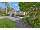 Exterior view of home with attractive landscaping, including lush plants and trees at 1171 Corinth Greens Dr, Sun City Center, FL 33573