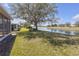 Lush backyard with pond view and mature trees, offering a serene and picturesque setting at 1205 Huntington Greens Dr, Sun City Center, FL 33573