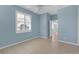 Well-lit bedroom with blue walls, ceiling fan, tile floor, and a window with plantation shutters at 1205 Huntington Greens Dr, Sun City Center, FL 33573