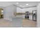 Well-lit kitchen features white cabinets, stainless steel appliances, and a stylish backsplash at 1205 Huntington Greens Dr, Sun City Center, FL 33573