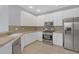 Spacious kitchen featuring stainless steel appliances, white cabinetry, and tile flooring at 1205 Huntington Greens Dr, Sun City Center, FL 33573