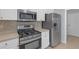 Updated kitchen featuring stainless steel appliances, white cabinetry, and a tiled backsplash at 1205 Huntington Greens Dr, Sun City Center, FL 33573