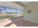 Enclosed lanai overlooking a pond and neighboring properties, providing a peaceful outdoor space at 1205 Huntington Greens Dr, Sun City Center, FL 33573