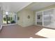 Spacious enclosed lanai with views of a lush yard, mature trees, and sliding door access at 1205 Huntington Greens Dr, Sun City Center, FL 33573