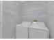 Functional laundry room with washer, dryer, and wire shelving for organization at 1205 Huntington Greens Dr, Sun City Center, FL 33573