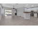 Open-concept living room with tile flooring, sliding glass doors to the lanai, and a seamless connection to the kitchen at 1205 Huntington Greens Dr, Sun City Center, FL 33573