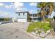 Beautiful light blue two-story home with two balconies, front yard landscaping, and a brick driveway at 13 Bellevue Dr, Treasure Island, FL 33706