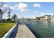 Waterfront property with a concrete walkway along the canal and boat dock access on a sunny day at 13 Bellevue Dr, Treasure Island, FL 33706
