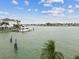 Scenic waterfront view featuring a boat docked near luxurious houses and blue skies at 13 Bellevue Dr, Treasure Island, FL 33706