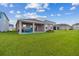 A view of the covered patio and spacious backyard from the lawn at 1409 Tropical Oasis Ave, Plant City, FL 33565