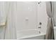 Clean bathroom with white tiled walls, shower-tub combo with curtain, and modern fixtures at 1409 Tropical Oasis Ave, Plant City, FL 33565