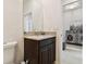 Stylish powder room features a granite countertop, dark wood cabinets, and elegant fixtures at 1409 Tropical Oasis Ave, Plant City, FL 33565