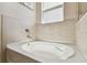 Relaxing bathroom featuring a large soaking tub, tile surround and a bright window above at 1409 Tropical Oasis Ave, Plant City, FL 33565