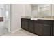 Elegant bathroom with double vanity, granite countertop, dark cabinets, and large mirror at 1409 Tropical Oasis Ave, Plant City, FL 33565