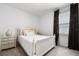 Serene bedroom with a white bed, complementing nightstand and neutral decor creating a restful atmosphere at 1409 Tropical Oasis Ave, Plant City, FL 33565