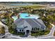 An aerial view of the clubhouse with a uniquely shaped pool and lush landscaping creating a resort-like atmosphere at 1409 Tropical Oasis Ave, Plant City, FL 33565