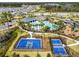 An aerial shot of the community's amenities, featuring a pool, playground, and sports courts, surrounded by lush greenery at 1409 Tropical Oasis Ave, Plant City, FL 33565