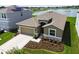 Aerial view of a single-Gathering home with well-manicured landscaping, pond and solar panels at 1409 Tropical Oasis Ave, Plant City, FL 33565