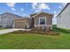 Charming single-Gathering home featuring a well-manicured lawn and a two-car garage at 1409 Tropical Oasis Ave, Plant City, FL 33565