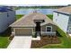 Aerial view of home with beautiful landscaping, lawn, and pond in the background at 1409 Tropical Oasis Ave, Plant City, FL 33565