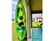Green and yellow kayak leaning against a column near the outdoor patio with a view of the lake at 1409 Tropical Oasis Ave, Plant City, FL 33565