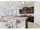 Bright kitchen features an island with bar seating and stainless steel appliances, with sightlines to the living area at 1409 Tropical Oasis Ave, Plant City, FL 33565
