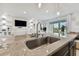 Modern kitchen island with granite countertops overlooking a spacious living area with a fireplace and access to the backyard at 1409 Tropical Oasis Ave, Plant City, FL 33565