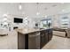 Stylish kitchen featuring a central island with stainless steel appliances and an open view of the living room area at 1409 Tropical Oasis Ave, Plant City, FL 33565
