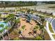 An aerial shot of the community playground featuring modern equipment and surrounded by palm trees at 1409 Tropical Oasis Ave, Plant City, FL 33565