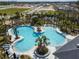 An aerial shot of the community pool with a unique shape, lounge chairs, and palm tree landscaping at 1409 Tropical Oasis Ave, Plant City, FL 33565