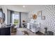 Adorable Bedroom with a patterned accent wall and a white crib, creating a cozy and inviting space at 17007 Barnwood Pl, Lakewood Ranch, FL 34211