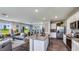 Open-concept kitchen, dining, and living room featuring stainless appliances, white cabinets, and modern furnishings at 17007 Barnwood Pl, Lakewood Ranch, FL 34211