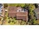 Aerial view of the home with a red brick pattern roof, lush greenery, and well-kept backyard at 17119 Rainbow Ter, Odessa, FL 33556