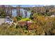 Aerial view of a charming home with a pool, lush greenery, and serene lake access, perfect for waterfront living at 17119 Rainbow Ter, Odessa, FL 33556