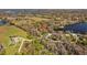 Expansive aerial view of a lakeside home with mature trees, a large lawn, and a long private driveway at 17119 Rainbow Ter, Odessa, FL 33556