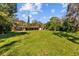 Vast backyard with lush green grass, mature trees, and a cozy single-story home, perfect for outdoor activities at 17119 Rainbow Ter, Odessa, FL 33556