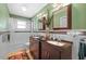 A bathroom with a dual sink vanity, granite counters, and decorative mirror at 17119 Rainbow Ter, Odessa, FL 33556