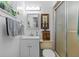 A white bathroom with a toilet, sink, cabinets, towels, and a shower with sliding glass door at 17119 Rainbow Ter, Odessa, FL 33556