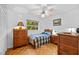 This bedroom features a window, a bed, ceiling fan, and 2 wood chests at 17119 Rainbow Ter, Odessa, FL 33556