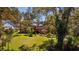 Charming single-story home nestled amongst mature trees and lush landscaping, creating a serene and inviting curb appeal at 17119 Rainbow Ter, Odessa, FL 33556