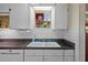 Bright kitchen with white cabinets, granite countertops, and a view of the plants on the window sill at 17119 Rainbow Ter, Odessa, FL 33556